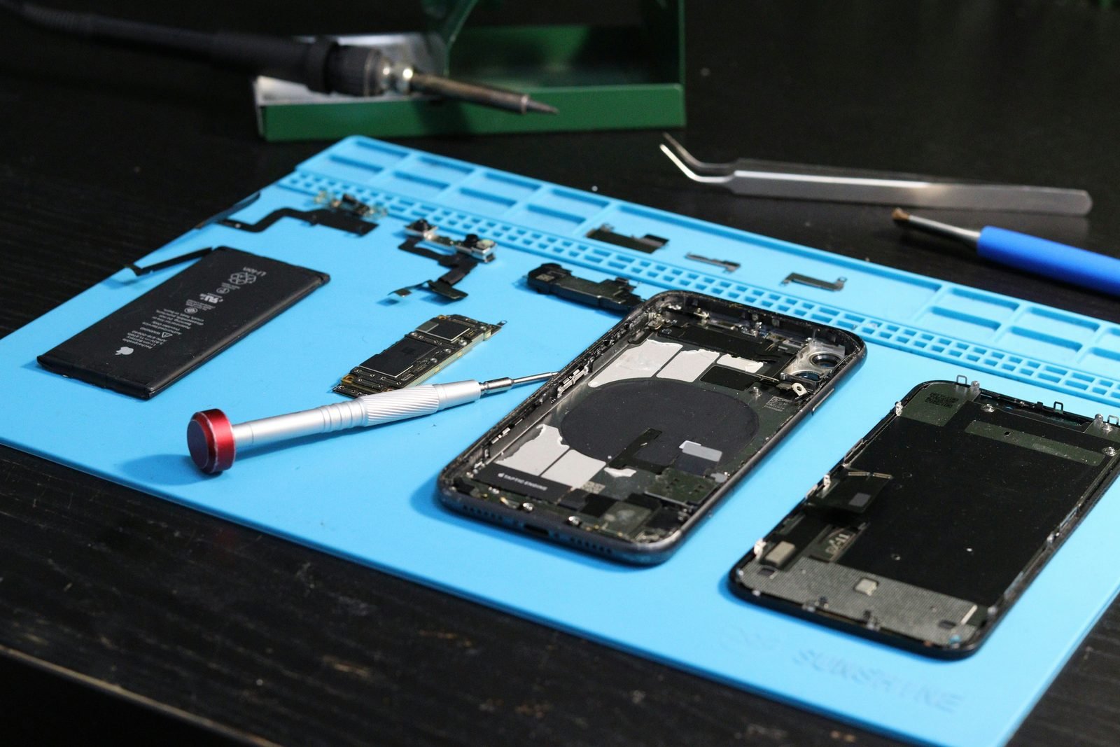 Micro-réparation d'iPhone sur tapis d'atelier
